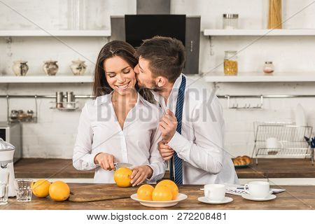 Boyfriend Kissing Girlfriend While She Cutting Oranges In Morning At Kitchen, Gender Stereotypes Con