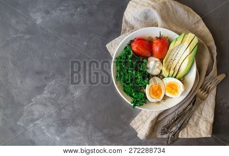 Quinoa Buddha Bowl With Baked Tomatoes, Avocado, Kale, Boiled Eggs And Greek Yogurt On Gray Concrete