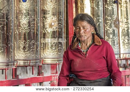 A Old Buddhist In Lharong Monastery And The Monk Houseson Surrounded In Sertar, Tibet.  Lharong Mona