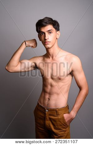 Young Handsome Persian Teenage Boy Shirtless Against Gray Backgr