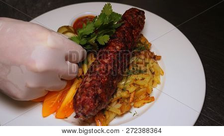 The Finished Dish With Kebab Meat And Potatoes Is Decorated With Greens And Vegetables. The Concept 