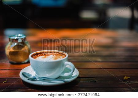 Hot Coffee Latte Cappuccino Spiral Foam On Wooden Table In Coffee Shop Cafe With Vintage Color Tone 