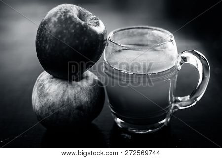 Apple Juice In A Transparent Glass With Two Raw Apples In  Side,close Up View.