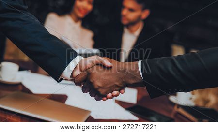 Close Up Of Business Handshake In Restaurant. Businessmans Having Meeting In Indoor Restaurant. Grou