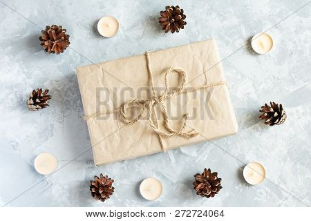 Christmas Decoration. Candles, Pine Cone And Gift On The Light Gray Background. Top View.