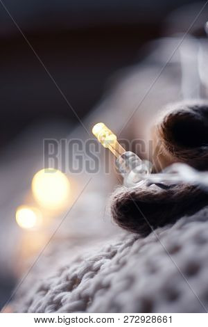 Christmas Garland Lies On Woolen Sweaters Prepared For Winter