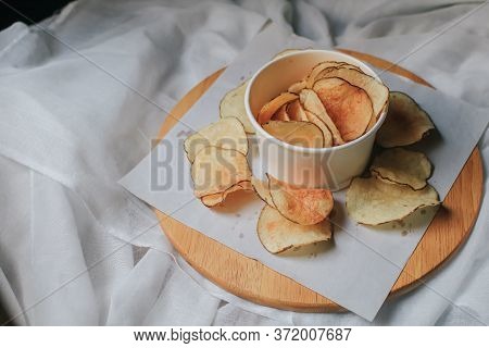 Fresh Homemade Deep Fried Crispy Potato Chips In White Box On A Wooden Tray, Top View. Salty Crisps 