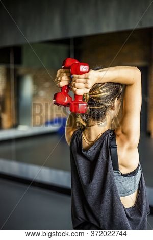 Young girl is doing fitness and different exercises in the gym.
Sport is health. Many sports equipme