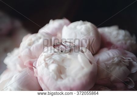 Wedding Rings On Peonies Flowers Macro Close Up. Jewellery And Gems