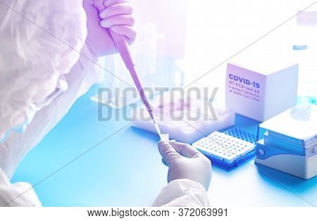 Sars-cov-2 Pcr Diagnostics Kit. Epidemiologist In Protective Suit, Mask And Glasses Works With Patie