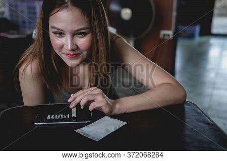 Young Drug Addict Woman Using Dollar Bill To Snort A Line Of Cocaine White Powder, Get High.
Young C