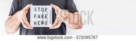 Fake News Infodemics During Covid-19 Pandemic Concept. Man Hands Holding Lightbox With Text Stop Fak