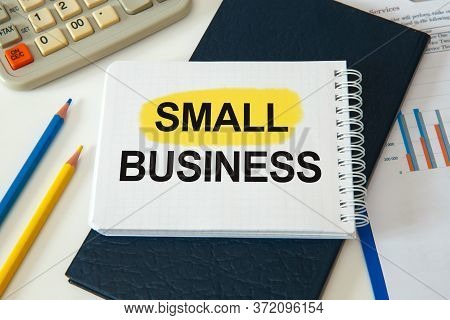 Desktop With Documents, Calculator And Notebook. On A Blockboard Inscription Small Business