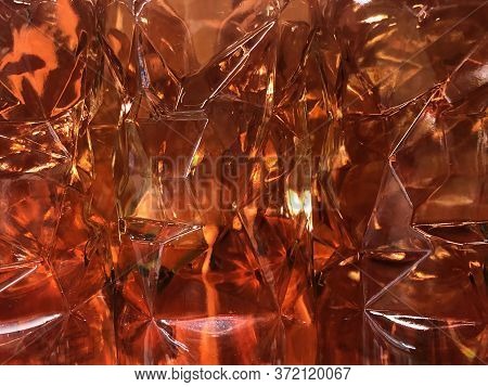 Amber Lights Shining Through Faceted Glass Wine Or Whiskey Bottles, Background Texture