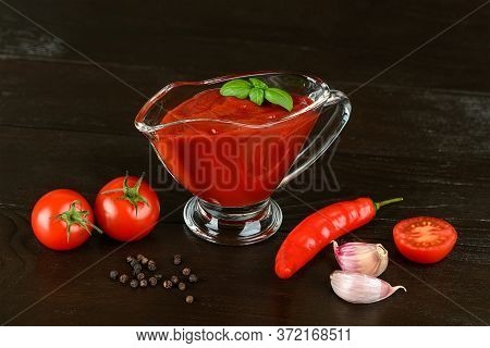 Tasty Thick Tomato Ketchup In A Glass Gravy Boat And Red Ripe Cherry Tomatoes, Garlic And Hot Pepper