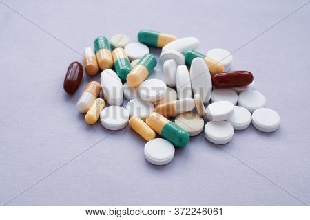 Colorful Pills And Capsules On A Purple Background, Macroshot Tablets
