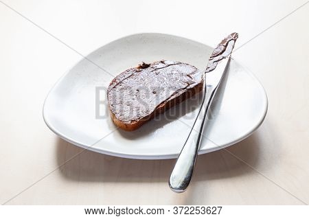 Slice Of Bread With Chocolatte And Hazelnut Spread And Knife On Plate On Table