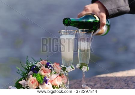 Hand Pouring Champagne Into Wedding Glasses Close Up