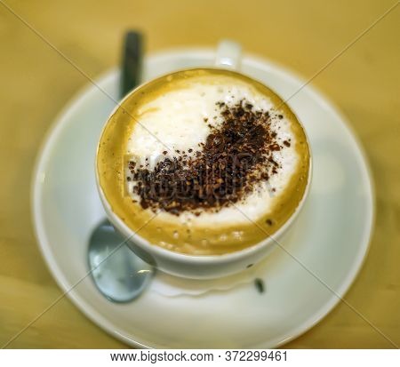 A Cup Of Frothy Coffee In A White China Cup With A Saucer. Cappuchino.
