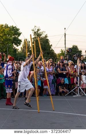 Genichesk, Ukraine - August 26, 2017: Men Compete In Walking On Wooden Stilts During Festival Tavriy