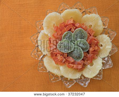 ผลไม้แห้งในชามโบราณบนพื้นหลังสีส้ม