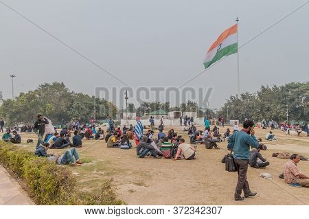 Delhi, India - January 24, 2017: People Sit At The Central Park At Connaught Place In Delhi.