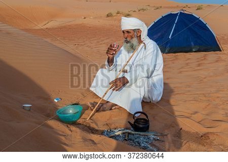 Al Wasil, Oman - March 6, 2017: Local Bedouin Prepares A Coffee In The Sand Dunes Of Sharqiya Wahiba