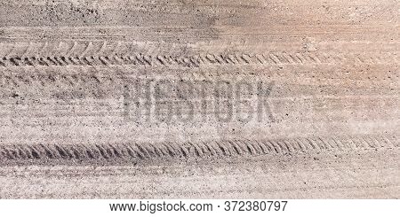View From Above On Texture Of Gravel Road With Car Tire Tracks