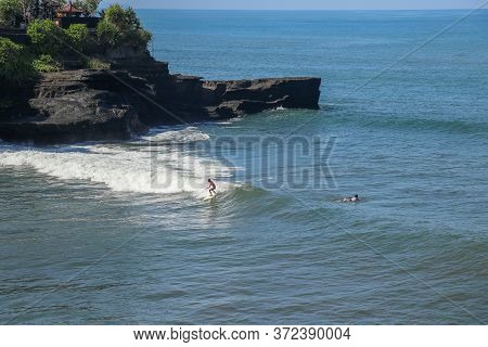 Surfer On The Wave, Catches A Wave, Surfing In The Pipe. Surfing In The Ocean On The Island Of Bali,
