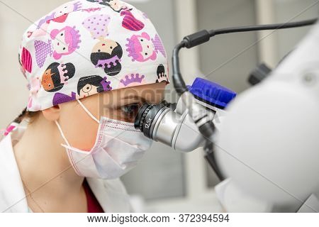 Young Scientist Looking Through A Microscope In A Laboratory. Young Scientist Doing Some Research. T