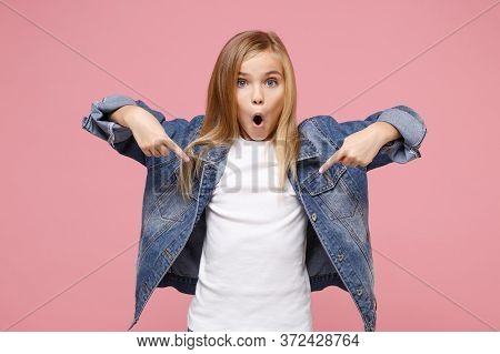 Shocked Little Blonde Kid Girl 12-13 Years Old In Denim Jacket Isolated On Pastel Pink Wall Backgrou
