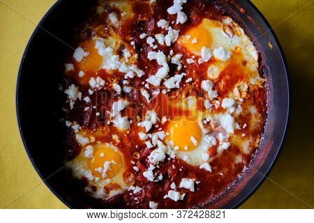 Shakshuka In A Frying Pan. Eggs Poached In Spicy Tomato Pepper Sauce