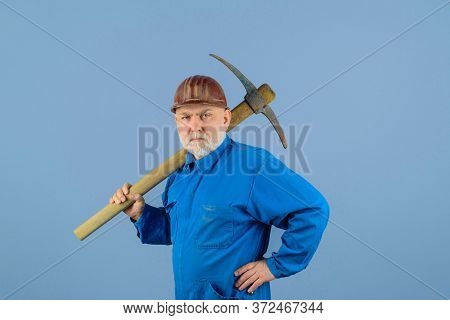 Serious Workman With Pickaxe. Construction Worker With Pick Axe. Male Laborer With Building Tools. M