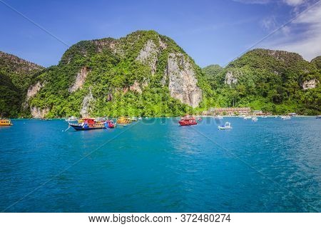 Greean Island And Colourful Boats In The Cyan Bay