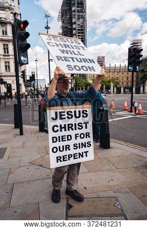 London / Uk - 06/20/2020: Street Preacher Outside The British Parliament Stating Jeus Christ Will Re