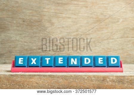 Tile Letter On Red Rack In Word Extended On Wood Background