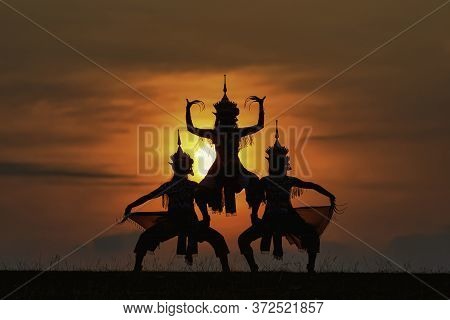 The Black Silhouette Of Three Manohra Actors Dancing In The Park In The Evening. Manohra Performance
