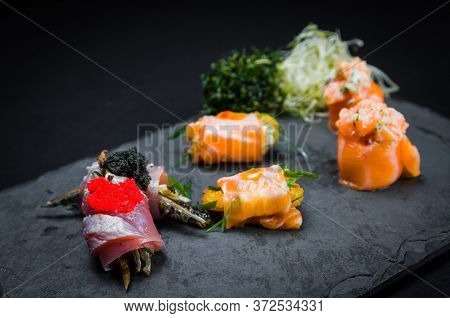 Sushi, Traditional Japanese Cuisine. Several Delicious Sushi On The Decorated Plate, Black Backgroun