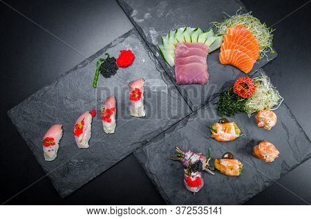 Sushi, Traditional Japanese Cuisine. Several Delicious Sushi On The Decorated Plate, Black Backgroun