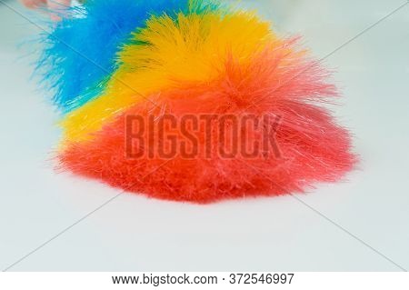 Woman's Hand With A Fluffy Dust Brush. A Woman Shakes Off Dust And Crumbs From A Table On Which Ther