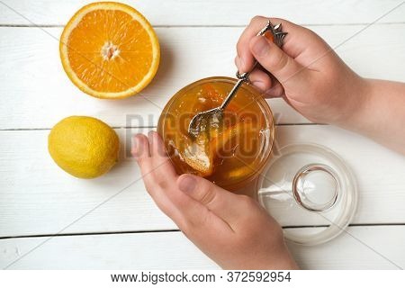Teenagers Hands Holding A Spoon With Orange And Lemon Jam. Homemade Orange Marmalade. Breakfast In R