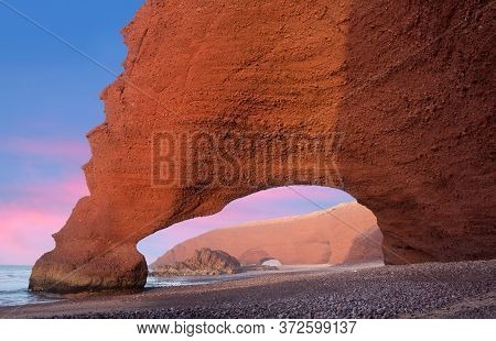 Famous Red Arches At Legzira Beach Near Sidi Ifni On Atlantic Coast In Morocco, Northern Africa. One