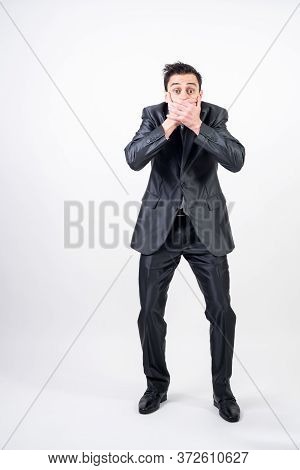 Man In Suit Covering His Mouth