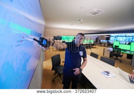 portrait of young male security operator working in a data system control room Working at workstation with multiple displays, security guard working on multiple monitors  Male computer operator monito