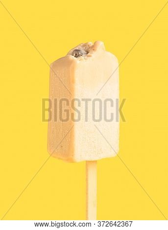 A Milk Tea Flavor Popsicle With Couple Of Bites On Yellow Background