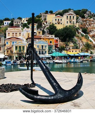 Symi, Greece - June 21, 2020: Anchor On The Embankment In The Port Of Symi Town, Symi Island, Greece