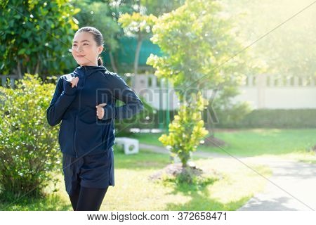 Portrait Of Asian Woman Workout Before Running At Village Park. Cheerful Runner Stretching And Warmi