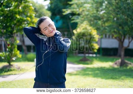 Portrait Of Asian Woman Wearing Earphones Listening To Music Was Sick With Fever At Park. Woman Exer