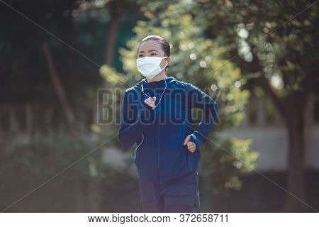 Portrait Of Asian Woman Wearing Earphones Listening To Music Was Sick With Fever At Park. Woman Exer