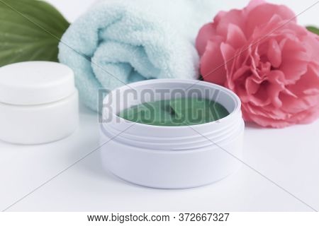 Hydrogel Patches To Care For And Moisturize The Skin Around The Eye, Flowers And Towel. The Concept 